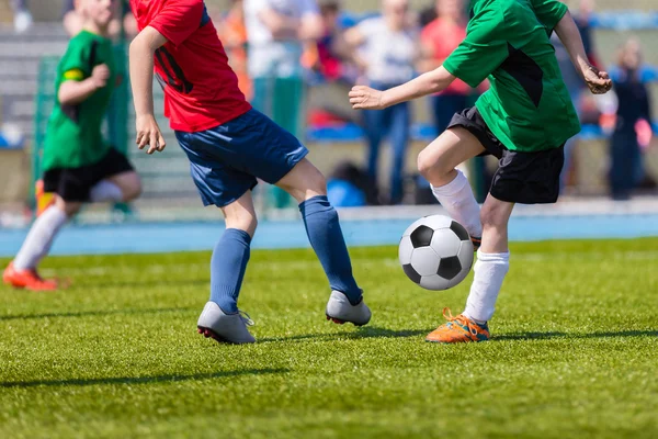 Young soccer football players playing match at sports field