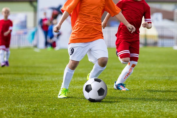 Niños jugando al fútbol. Jugadores corriendo y pateando pelota de fútbol. Torneo de escuela deportiva para equipos de fútbol juvenil —  Fotos de Stock