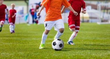 Genç erkek Futbol Spor sahada futbol oyunu oynarken. Futbolcular spor gömlek içinde çalışıyor. Çalışan ve futbol topu tekmeleme çocuklar.