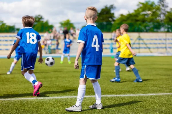 Juego de fútbol entre equipos juveniles. Jóvenes jugando fútbol en el campo de deportes —  Fotos de Stock