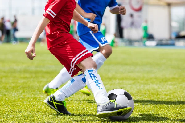 Soccer players kicking ball on sports field. Competition game be