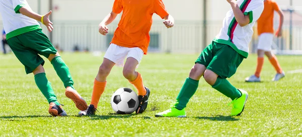 Young boys children in uniforms playing youth soccer football game tournament. Horizontal sport background.