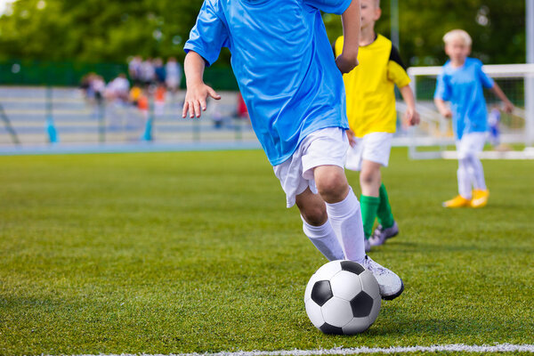 Training and football match between youth soccer teams. Young boys playing soccer game. Competition between players running kicking soccer ball. Game of football tournament for kids. Sport background.