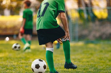 Genç futbolcu dizinden sakatlanmış. Antrenman takımındaki futbolcu çocuk. Futbolcu acı çekiyor