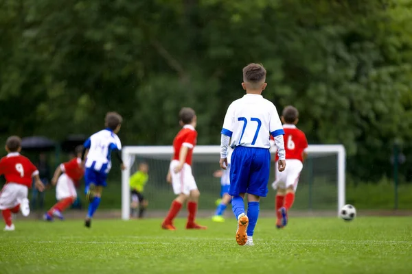 足球小子在玩游戏 快乐儿童踢足球锦标赛比赛 泽西蓝衣队和红衣队的选手 — 图库照片