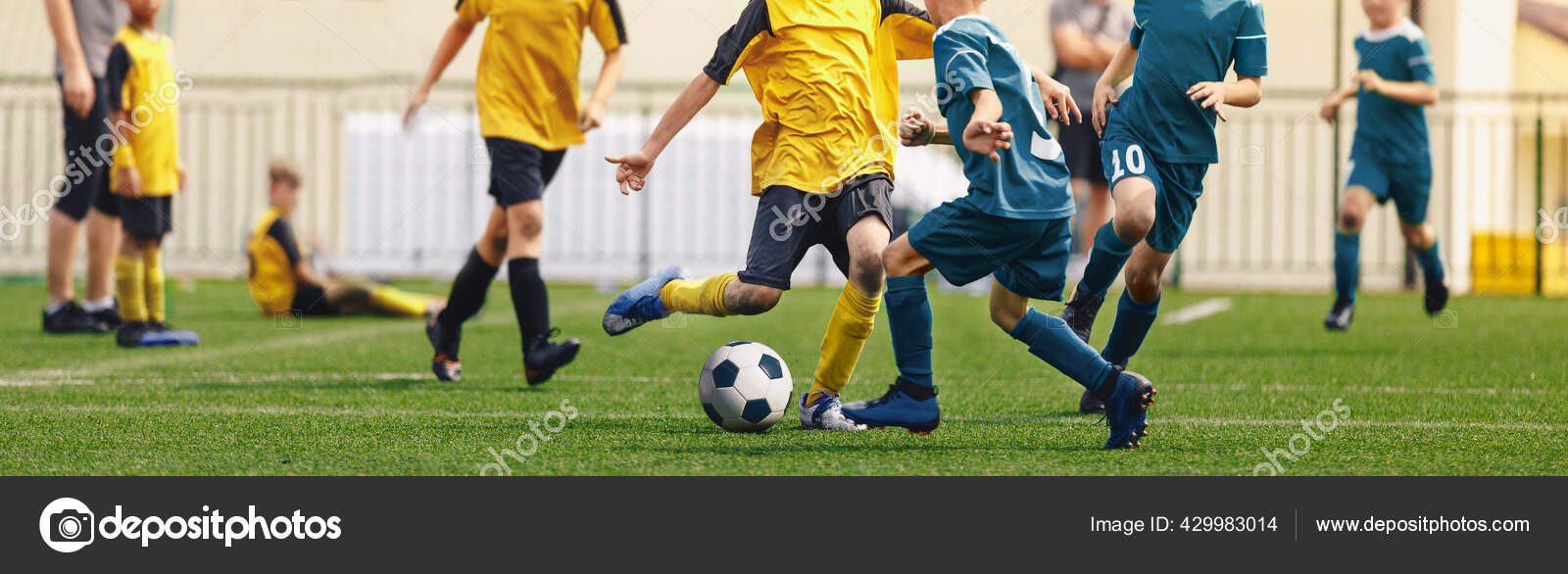 Young Football Players Kicking Ball on Soccer Field. Soccer