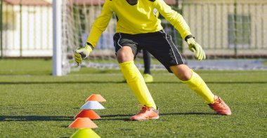Eğitim Eylemlerinde Genç Futbol Kalecisi. Erkek Futbolcu Hız Yeteneklerini Geliştiriyor. Antrenman seansında kaleci çocuk. Külahlar Sırasında Yürüyen Futbolcu