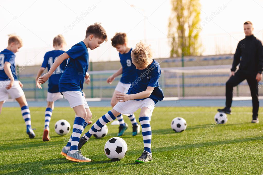 Soccer Education for Young Boys. Physical Education Class for School Children. Young Coach With Kids in Team on Training Unit. Youth Team Coach Training School Boys in Football Soccer