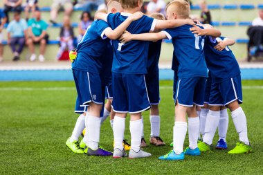 Futbol Takımı Oyuncuları Bir Grupta Toplanıyor. Çocuklar maçtan önce spor yapıyor ve motive ediyor. Blue Soccer Jersey Spor Giyim 'deki çocuklar. Mutlu Okul Çocukları