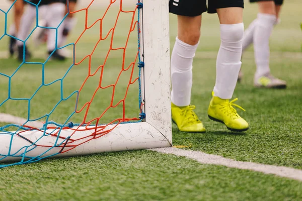 Spor Kramponlarındaki Futbolcuların Bacakları. Football Goal Post ve Soccer Net. Spor Eğitim Sahası Arkaplanı
