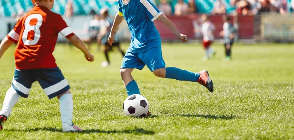 孩子们在足球场上玩游戏 男孩子们在足球比赛中竞争 穿着红色和蓝色足球球衣的孩子 — 图库照片