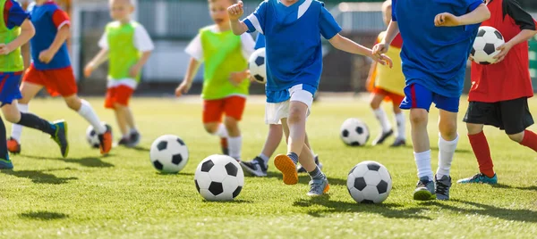 足球学校的训练 孩子们在草地练习场上跑足球球 穿着色彩艳丽的衣服参加体育运动的儿童 — 图库照片
