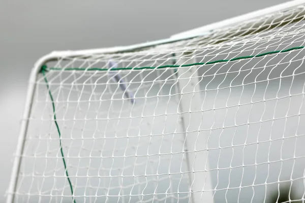 Soccer football equipment background. White soccer net on a goal. Soccer net nodes. Blurred goal post in the background