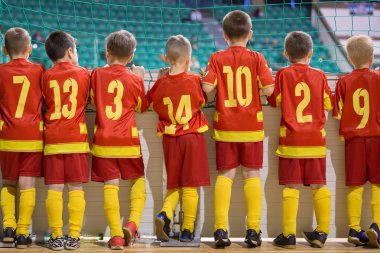 Futbol futsal gençlik takımı bir bankta. Bir kenarda bekleyen çocuklar