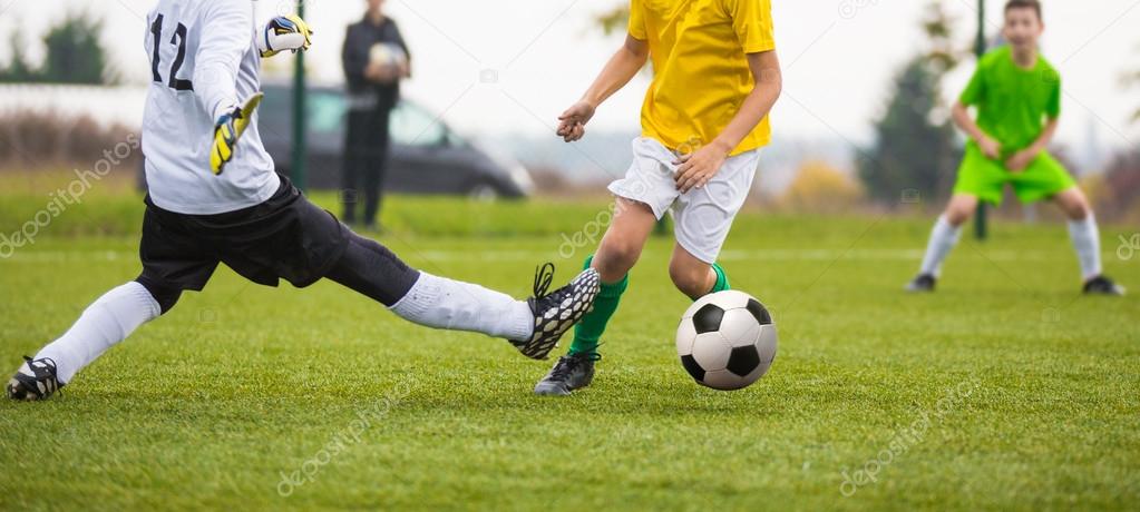 Young soccer goalkeeper save and running forward