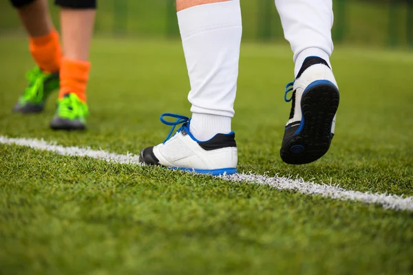 Jugador de fútbol cruzando la línea blanca en el campo —  Fotos de Stock