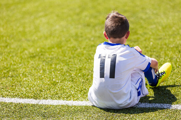 Young boy watching football match. Youth reserve player of footb