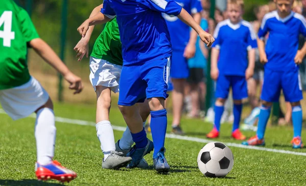 Çocuklar için futbol maçı. Genç erkek futbol oyunu oynarken.