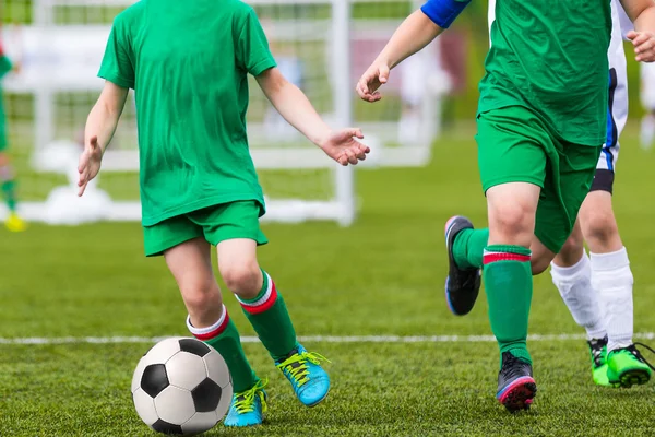 Meninos chutando futebol no campo de esportes — Fotografia de Stock