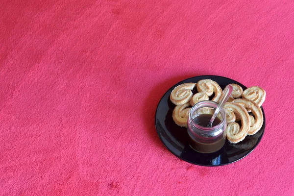 Kahveyi siyah bir tabakta, kırmızı masa örtüsünde avuç içi hamur işleri ile servis ediyorum. Sol tarafta yazacak yer var.