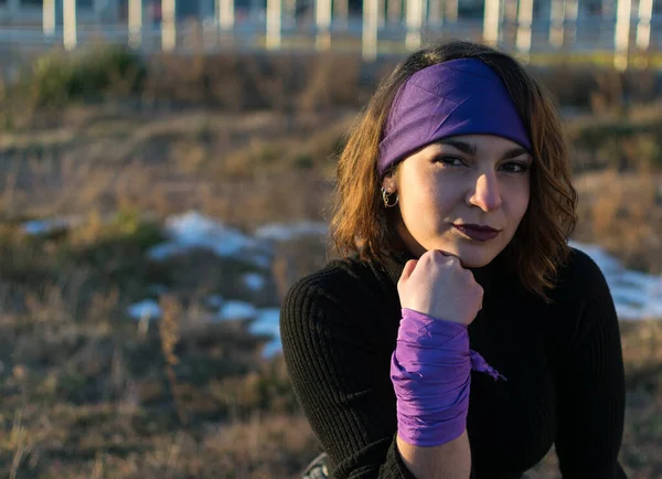 Mor başörtüsü ve bilek atkısı olan beyaz, genç bir kadın. Feminizm kavramı.