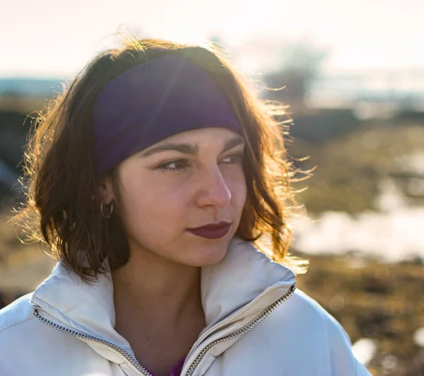 Mor saç bandı ve beyaz önlüklü beyaz beyaz kadın ufka bakıyor. Gençlik ve güzellik kavramı