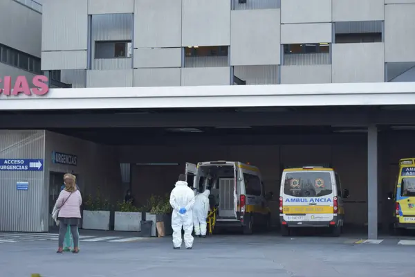 Valladolid, İspanya 02-12-21. İki hastane çalışanı Valladolid Klinik Hastanesi 'nin acil servisindeki bir hastayı sedyeden çıkardı..