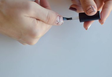 Kadınların elleri tırnak boyamak için fırçayı kullanır.