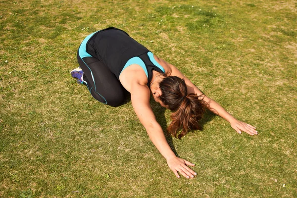Beyaz Kafkasyalı kadın çimlerin üzerinde geriniyor.