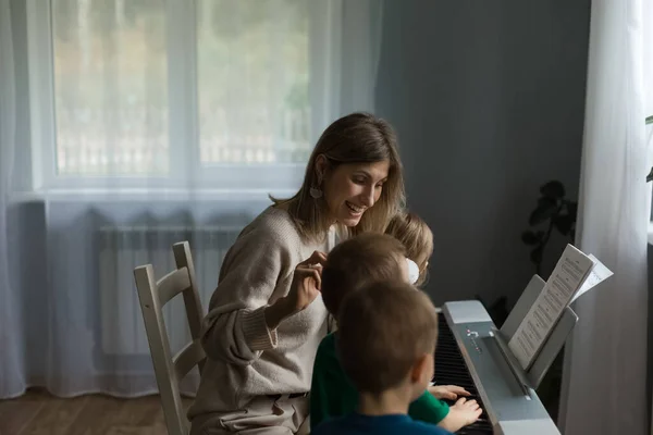 Children and mom communicate with a synthesizer.