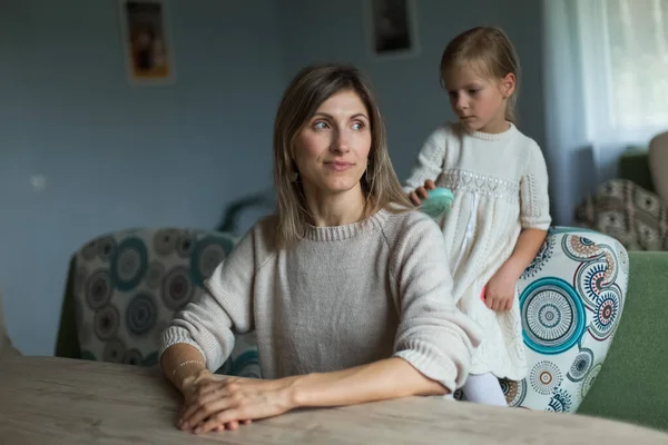 La hija trenza el pelo de sus madres. Muebles para el hogar. —  Fotos de Stock