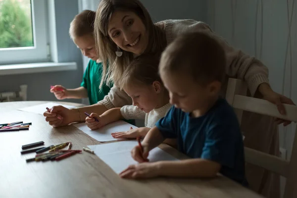 Anya három gyerekkel rajzol. Döntetlen filctollal. — Stock Fotó