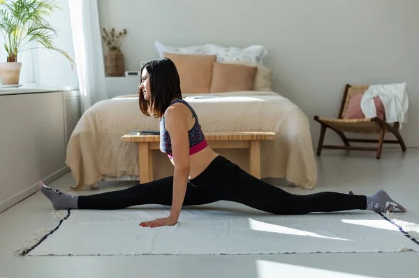 Chica se dedica a la gimnasia, yoga, en su casa. — Foto de Stock