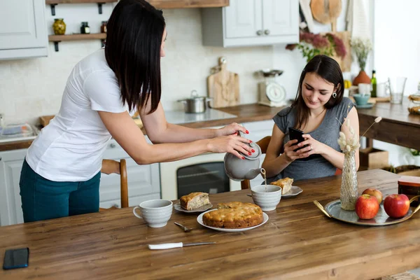 Masada iki kız kek tatlısı ile çay içecekler..