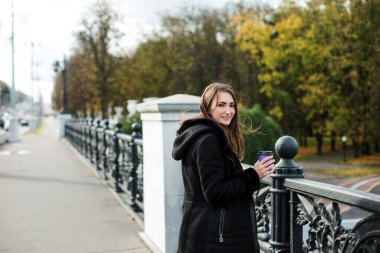 Şehirde ceketli bir kız var. Sahte çitin orada bir bardak var..