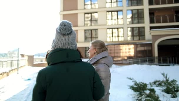 Stara kobieta i dziewczyna stoją na ulicy, w mieście i komunikują się. — Wideo stockowe