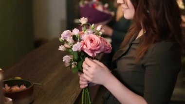 Bir buket pembe çiçek genç bir kızın ellerinde.