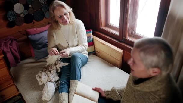 Dorosłe kobiety czytają książkę i robią na drutach.. — Wideo stockowe