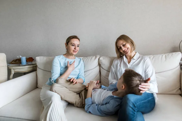 Teenager lies in the lap of an adult woman and everyone communicates — Stock Photo, Image