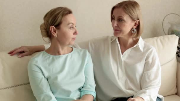 Zwei erwachsene Frauen sitzen auf der Couch und reden miteinander. — Stockvideo