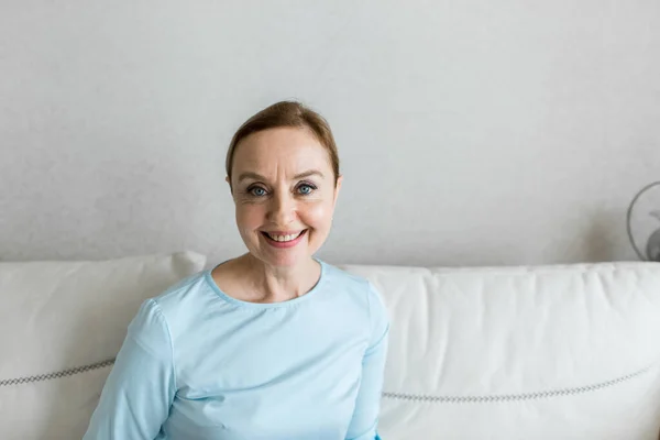 Yetişkin bir kadın kameraya mutlu bir şekilde bakar. Portre.