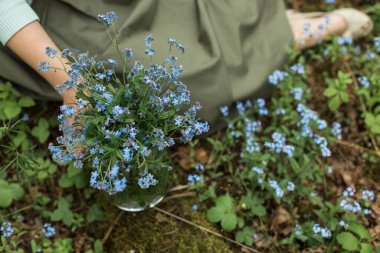 Bir buket taze unutma-beni-nots kadın eliyle tutulur.. 