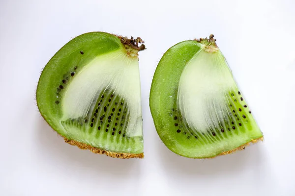 Beyaz arka planda kesilmiş bir kivinin iki dilimi..