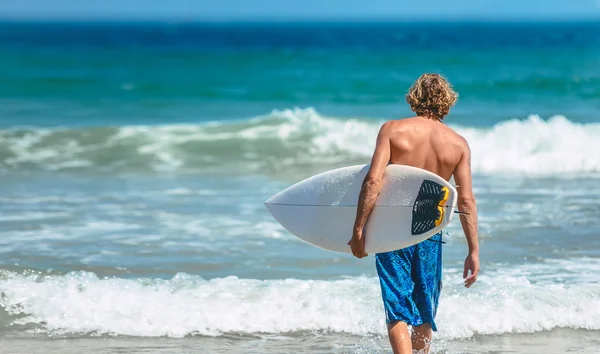 Mann im Badeanzug hält Surfbrett — Stockfoto