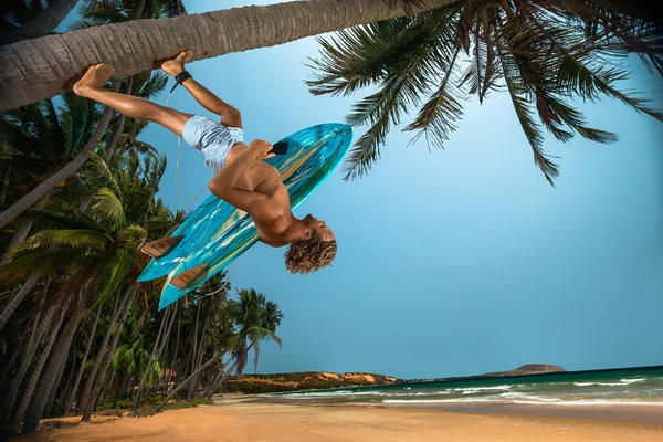 코코넛 팜에 서핑 보드와 함께 남자 — 스톡 사진