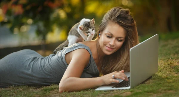 Menina e um gato na grama — Fotografia de Stock