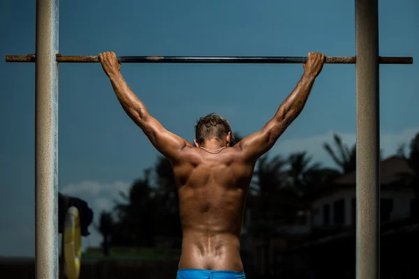Athlete doing pull-up on horizontal bar — Stock Image Athlete doing pull-up on horizontal bar Stock Image