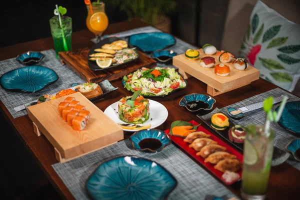 日本菜桌上的侧视图 花盘和意大利寿司与各种配菜对齐 — 图库照片