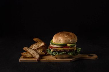 Hamburger ekmeğin içinde kızarmış patatesle birlikte fast food konseptinde sunuluyor.