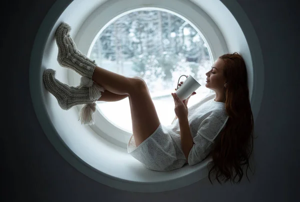 Krásná Dívka Bílém Oblečení Leží Kulatém Parapetu Okna Pít Kávu — Stock fotografie
